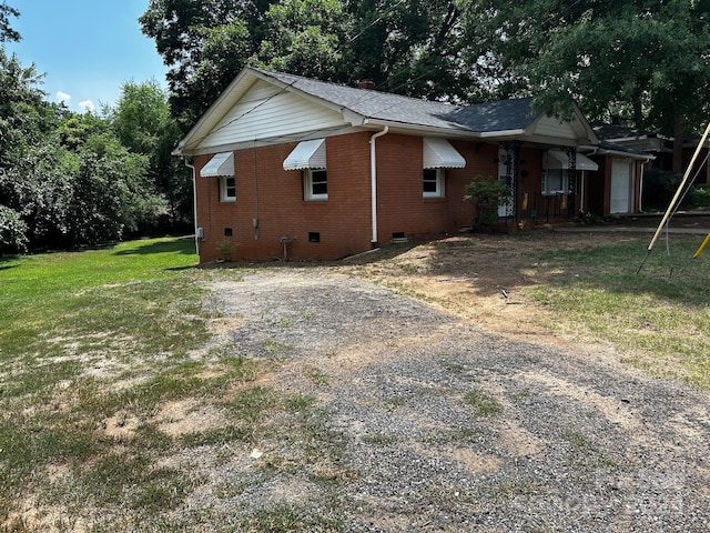 view of side of home with a lawn