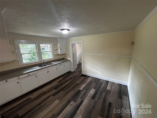 kitchen featuring sink, white cabinets, a textured ceiling, ornamental molding, and dark hardwood / wood-style floors