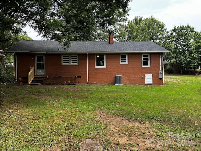 rear view of property featuring a yard and central AC unit