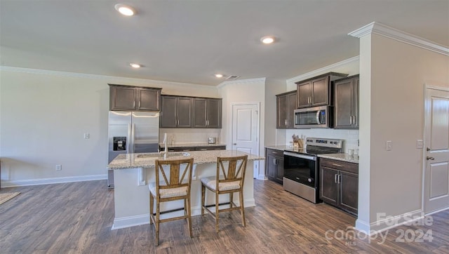 kitchen with tasteful backsplash, stainless steel appliances, an island with sink, ornamental molding, and dark hardwood / wood-style floors