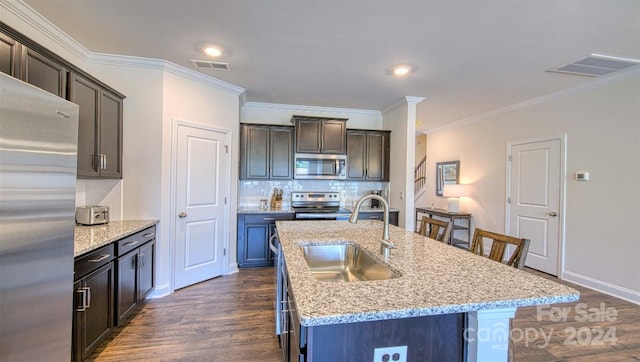 kitchen with dark wood-type flooring, stainless steel appliances, decorative backsplash, sink, and ornamental molding