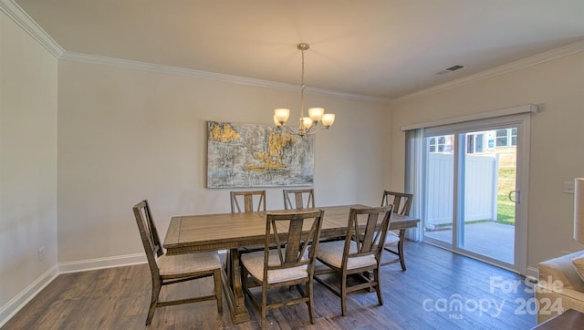 dining space featuring dark wood-type flooring, a chandelier, and ornamental molding