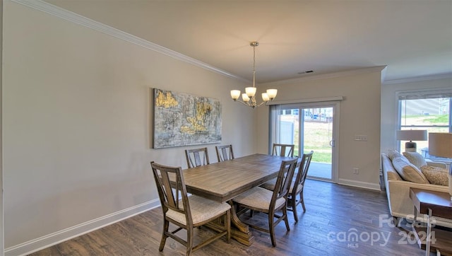 dining space featuring an inviting chandelier, crown molding, and dark hardwood / wood-style floors