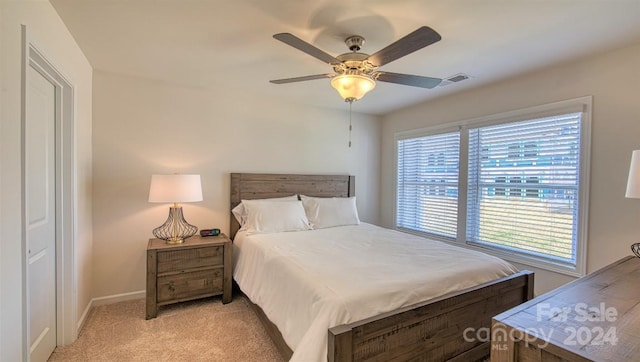 carpeted bedroom with multiple windows and ceiling fan