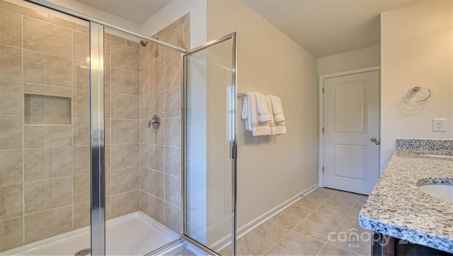 bathroom with tile patterned floors, a shower with door, and vanity