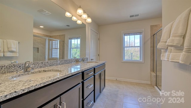 bathroom with walk in shower, tile patterned flooring, and dual bowl vanity