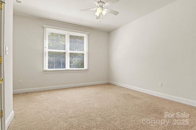 unfurnished room with carpet floors, baseboards, and a ceiling fan