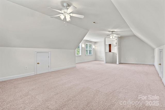 additional living space with visible vents, baseboards, light colored carpet, lofted ceiling, and ceiling fan