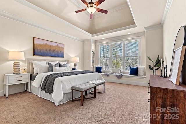 carpeted bedroom with ceiling fan, baseboards, ornamental molding, and a raised ceiling