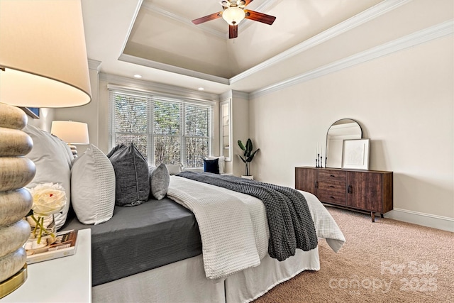 bedroom featuring carpet floors, a tray ceiling, crown molding, a ceiling fan, and baseboards