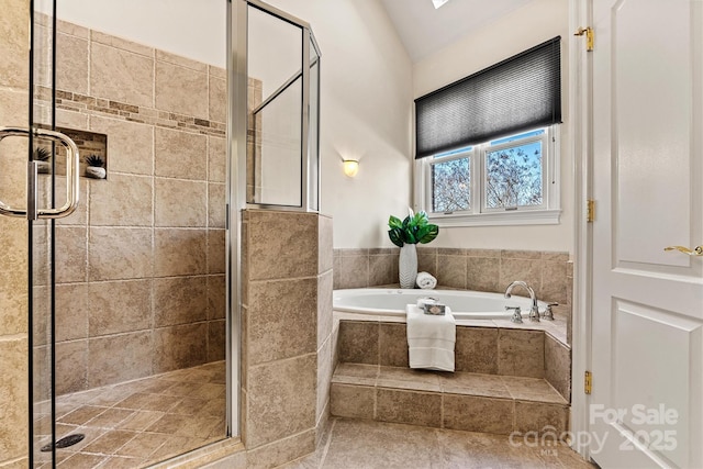 bathroom with a stall shower, vaulted ceiling, and a garden tub