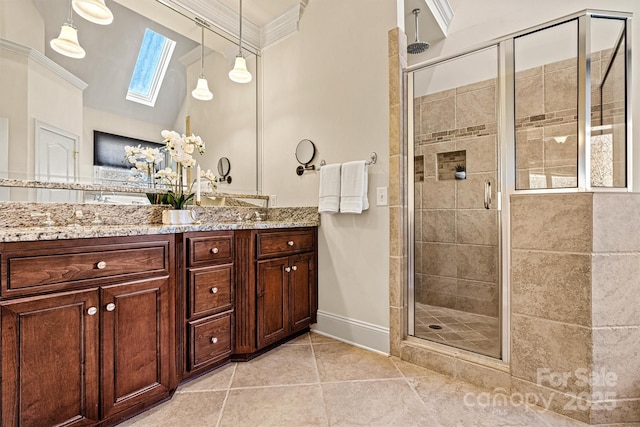 full bath featuring double vanity, a skylight, a shower stall, and ornamental molding