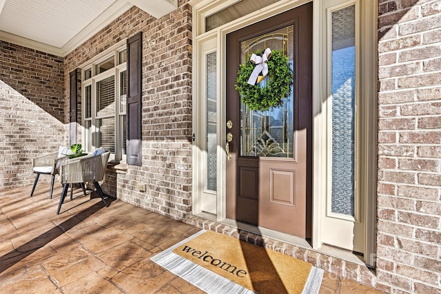 doorway to property featuring brick siding