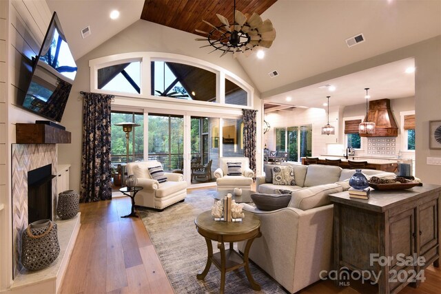 living area with light wood-style flooring, visible vents, and a fireplace with raised hearth