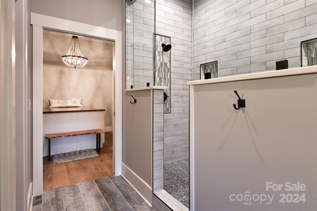 full bath featuring baseboards, walk in shower, and wood finished floors