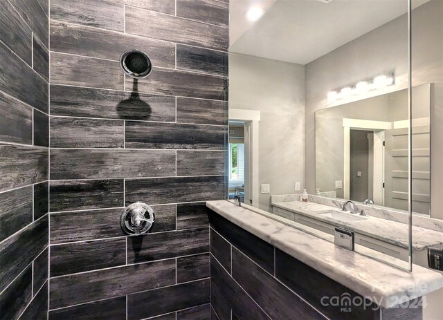 bathroom featuring a tile shower and vanity