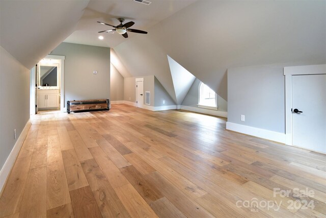 additional living space with lofted ceiling, baseboards, visible vents, and light wood finished floors