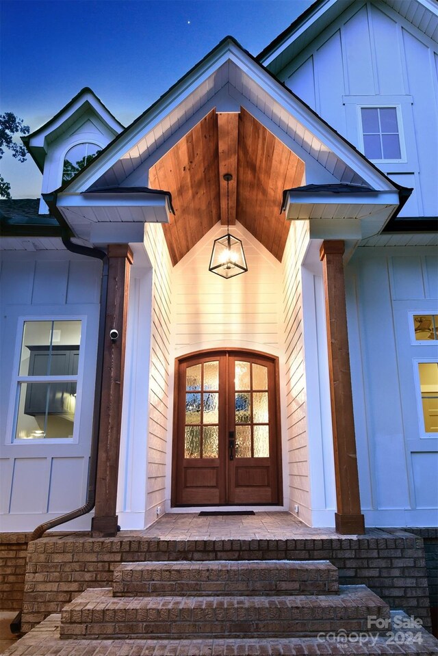 doorway to property with board and batten siding and french doors