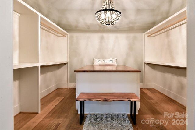 walk in closet featuring a chandelier and wood finished floors