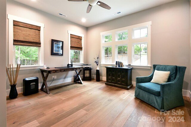 interior space featuring light wood-type flooring, visible vents, ceiling fan, and baseboards