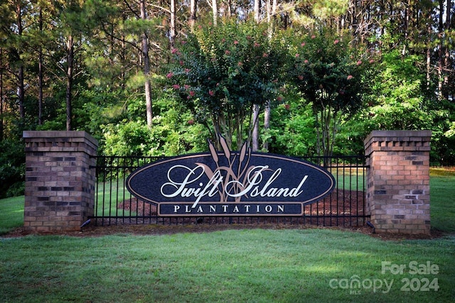 community sign featuring a yard and fence