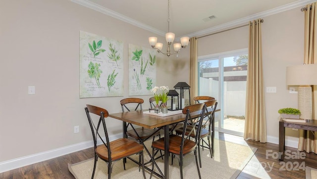 dining area with dark wood-type flooring, crown molding, and an inviting chandelier