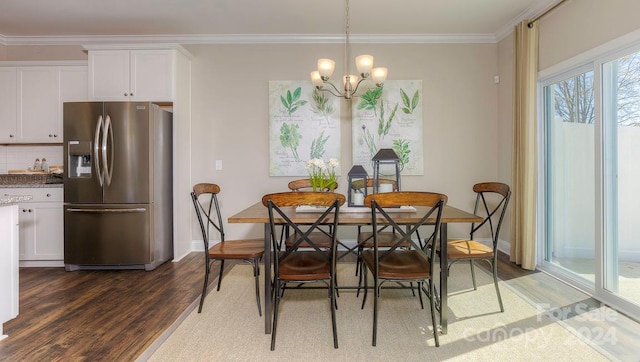 dining area with dark hardwood / wood-style flooring, crown molding, and a chandelier