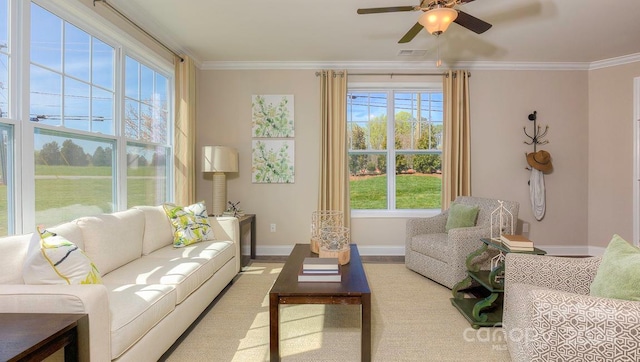 living room with ceiling fan, ornamental molding, and a healthy amount of sunlight