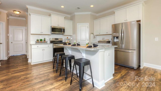 kitchen featuring a center island with sink, stainless steel appliances, and white cabinetry