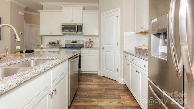 kitchen featuring backsplash, sink, white cabinetry, dark wood-type flooring, and stainless steel appliances