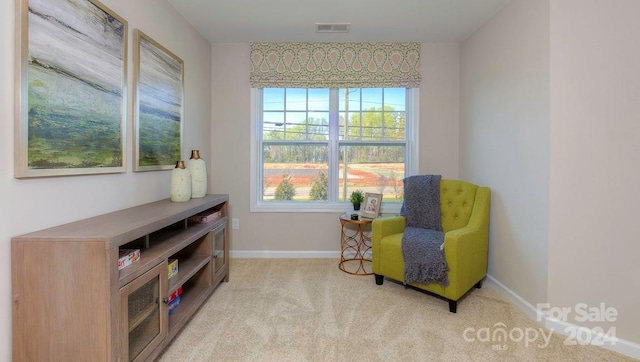 sitting room featuring light colored carpet