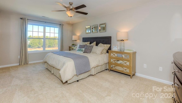 bedroom with ceiling fan and light carpet