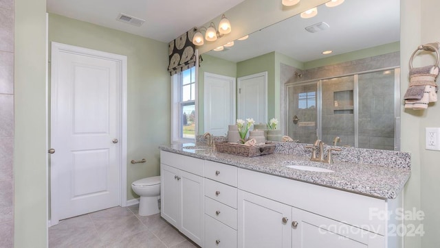 bathroom featuring a shower with shower door, vanity, tile patterned floors, and toilet