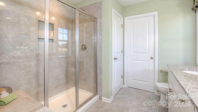 bathroom with vanity, toilet, tile patterned flooring, and walk in shower