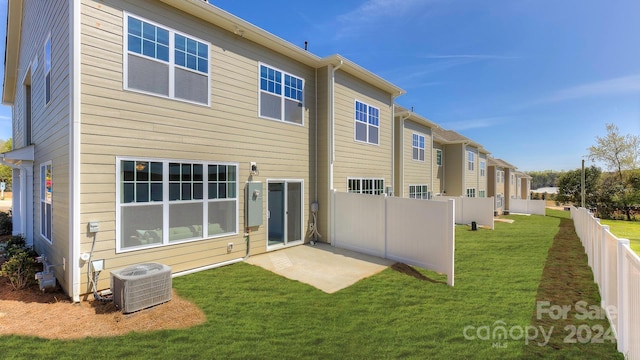 rear view of house with a lawn and central AC