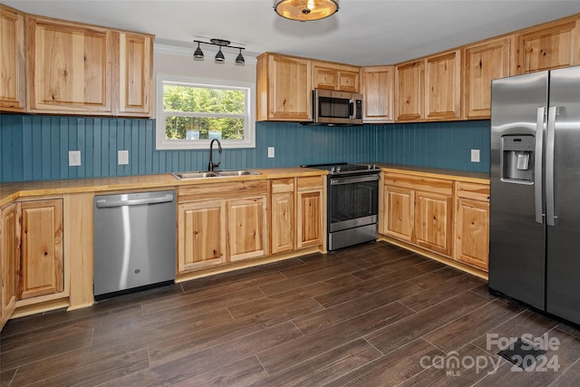 kitchen featuring light brown cabinets, dark wood-type flooring, a sink, light countertops, and appliances with stainless steel finishes