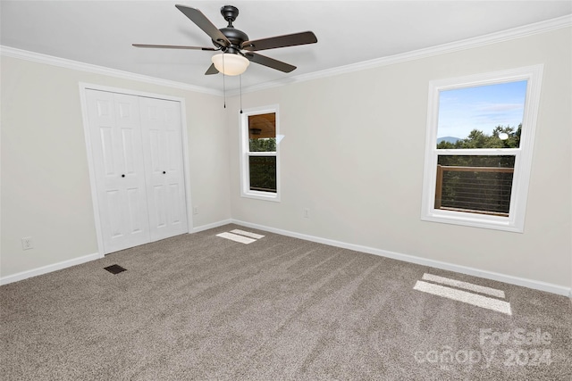 unfurnished bedroom featuring carpet flooring, crown molding, visible vents, and baseboards