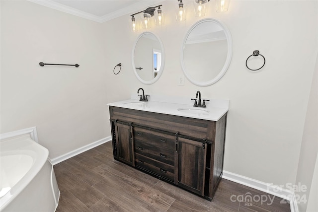 bathroom featuring crown molding, double vanity, a sink, and wood finished floors