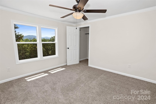 carpeted empty room with ornamental molding, ceiling fan, and baseboards