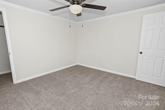 unfurnished bedroom featuring carpet, crown molding, and baseboards