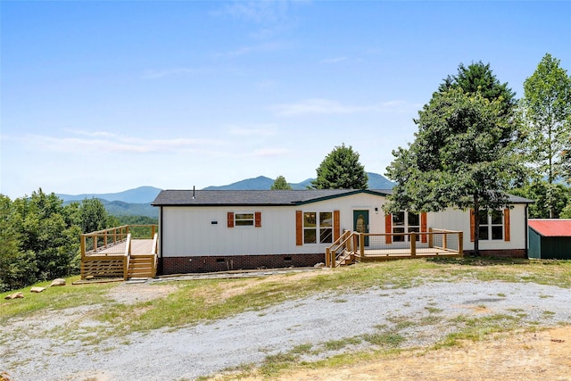 view of front of property featuring crawl space and a deck with mountain view