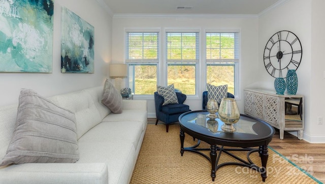 living room featuring wood-type flooring, a wealth of natural light, and ornamental molding