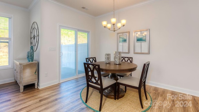 dining space with a notable chandelier, crown molding, and light hardwood / wood-style flooring