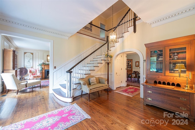 entryway with ornamental molding and wood-type flooring