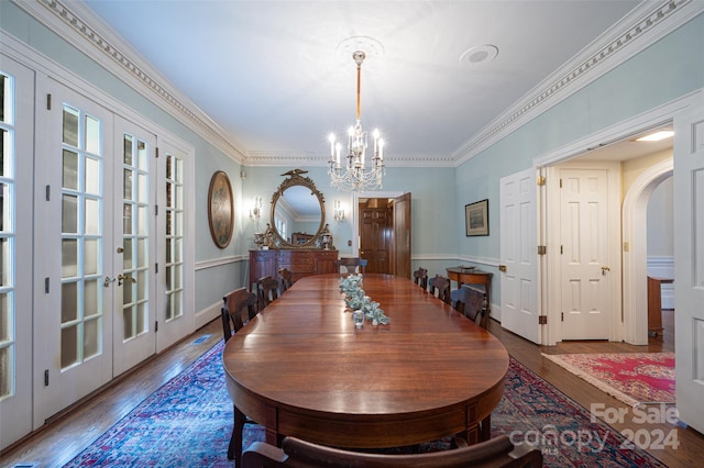 dining room featuring french doors, ornamental molding, hardwood / wood-style floors, and a notable chandelier