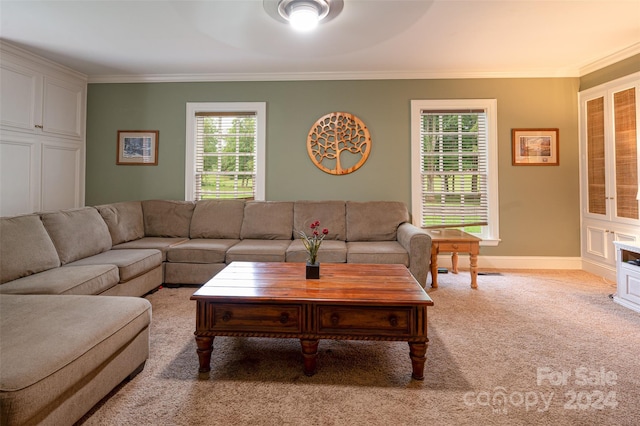 living room featuring ceiling fan, light colored carpet, crown molding, and a healthy amount of sunlight