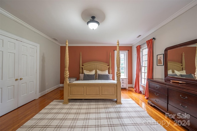 bedroom with light hardwood / wood-style floors, a closet, and ornamental molding