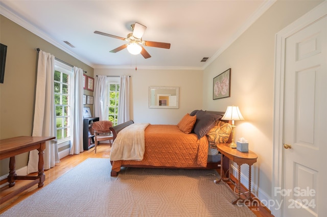 bedroom featuring ceiling fan, ornamental molding, and light wood-type flooring