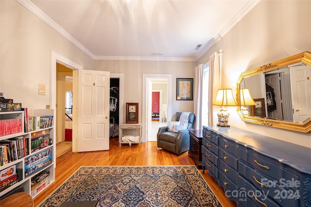 sitting room with light hardwood / wood-style flooring and crown molding