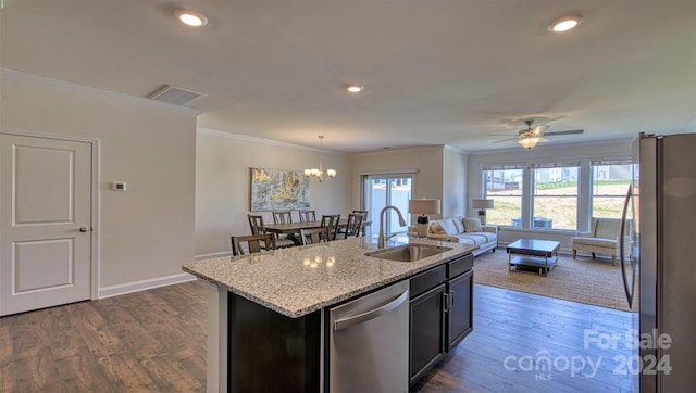 kitchen with stainless steel appliances, a kitchen island with sink, light stone countertops, ornamental molding, and sink